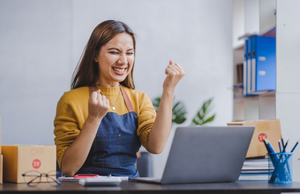 Female entrepreneur reading positive reviews on her laptop.